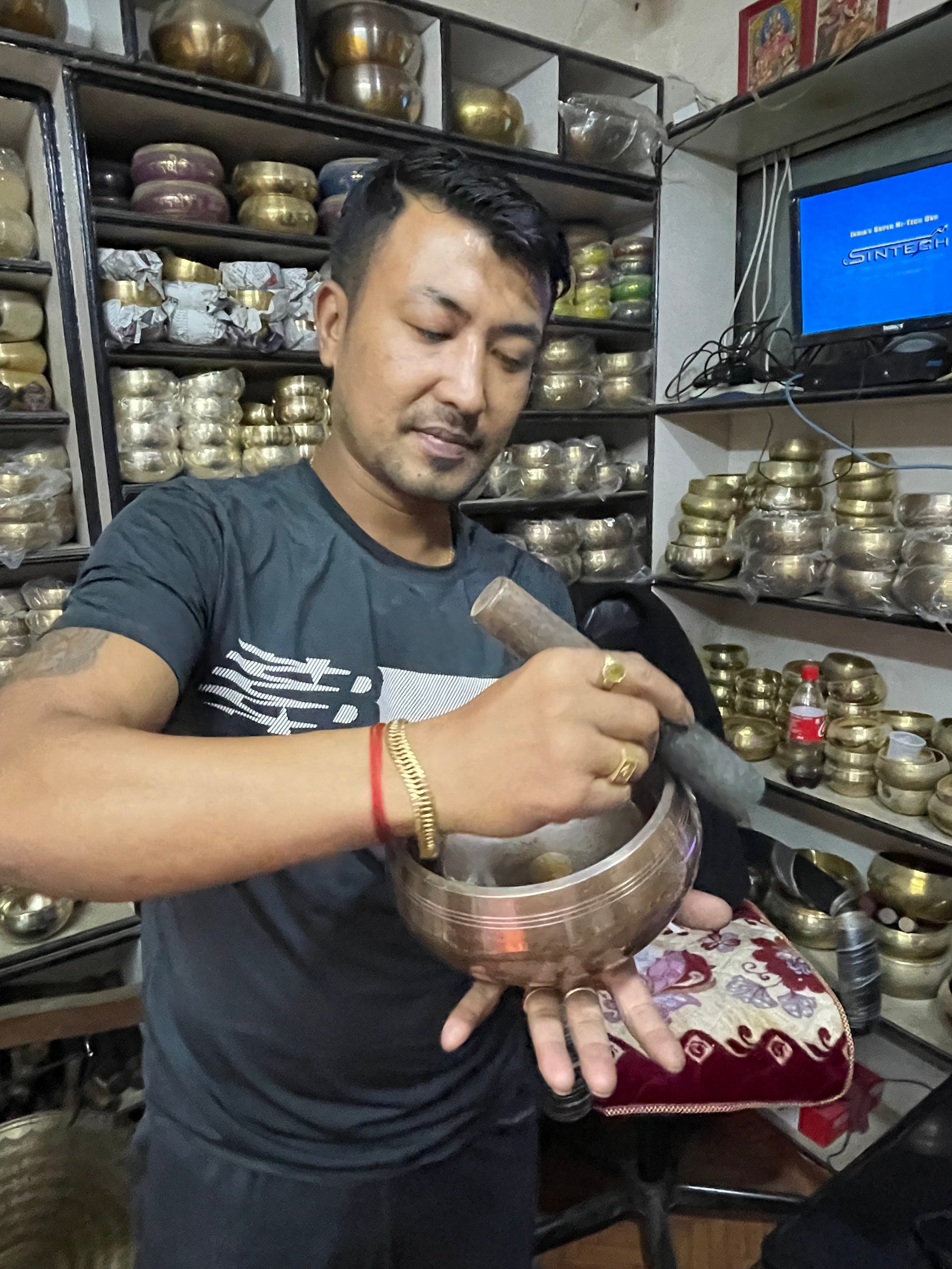 Man with Himalayan singing bowl store holding a singing bowl